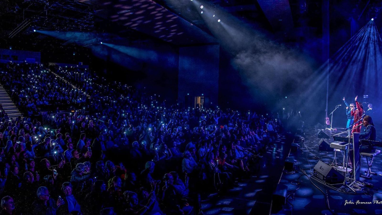 A theatre crowd with phones lit